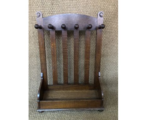 An Arthur Simpson, The Handicrafts, Kendal, Arts and Crafts oak stick stand or whip rack, bearing an inset label, 66 cm x 94 