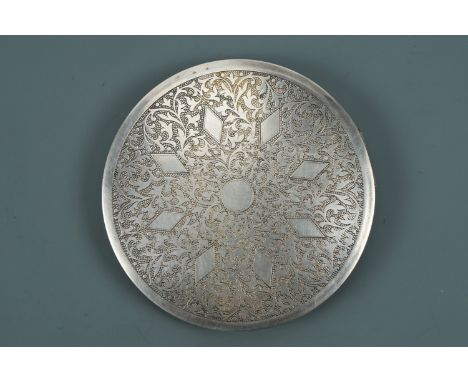 An Asian white metal powder compact, the front etched in a pattern of radiating lozenges on a foliate scroll and stipple grou