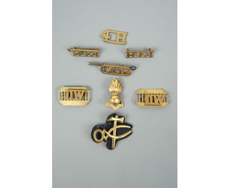 A small group of British army brass shoulder titles, a pioneer's qualification badge etc