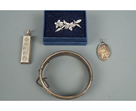 An engraved silver hinged bangle, together with a silver ingot pendant, and white metal St Christopher pendant and a Silver S