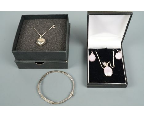 Contemporary white metal jewellery comprising an earrings and pendant necklace suite, a heart-shaped double locket and bangle