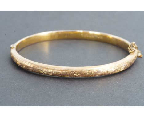A Victorian 9ct rose gold hinged bangle, the face engraved with scrolling foliage, Chester, 1898, in original fitted case, (c