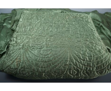 A vintage hand-stitched green satin quilted single bedspread
