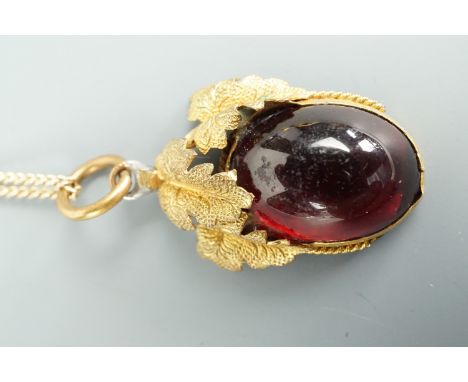 A vintage pendant modelled as a fruit and set with a garnet-coloured oval cabochon, on a yellow metal fine-link neck chain, c
