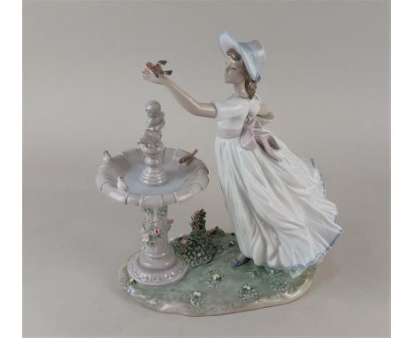 A large Lladro porcelain figure 6106 'Spring Joy' of a girl with a robin beside a fountain 27.5cm high, boxed