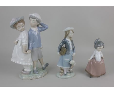 A Lladro porcelain figure group of a pair of children, 26cm high, a Lladro figure of a schoolgirl holding a satchel and doll 