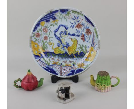 A faience plate with figural decoration 25cm diameter, together with three ceramic items to include two miniature novelty tea