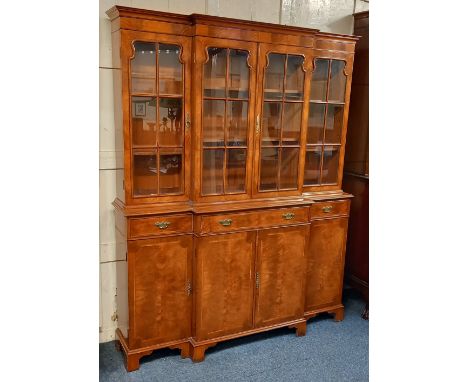 A Georgian style walnut breakfront library bookcase with central twin glazed panel doors flanked by two further doors, base w