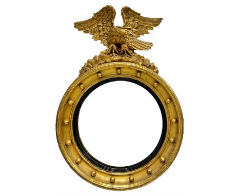 Regency gilt framed convex mirror, the eagle pediment with outstretched wings and turned head, surmounted on rocks, the circu