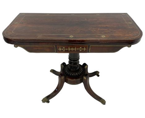 Regency rosewood and brass inlaid card table, the rectangular fold-over and swivelling top with rounded corners, inlaid with 