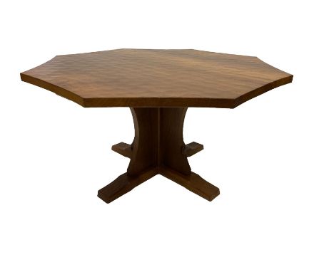 Mouseman - adzed oak octagonal concave dining table, raised on cruciform base, the supports and sledge feet also adzed, carve