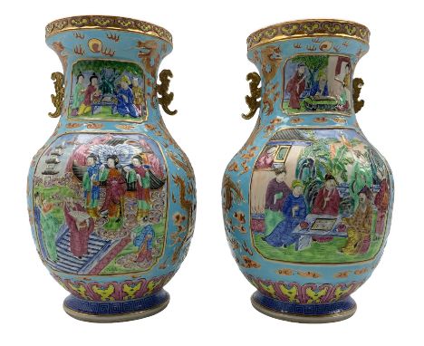 Pair of Chinese Canton Famille Rose twin handled vases, each of baluster form, decorated in low relief with four opposed shap