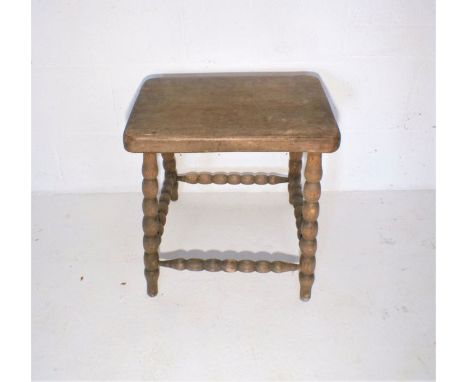 An oak stool, with bobbin turned legs and supports.