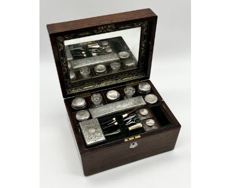 A mahogany dressing box with secret drawer containing various silver plated dressing pots, bottles, inkwells, manicure set et