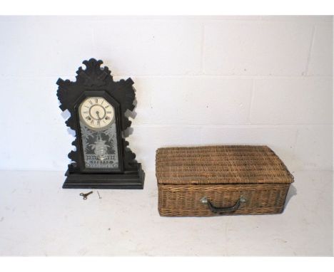 An Ansonia wooden mantle clock, along with a wicker picnic hamper.