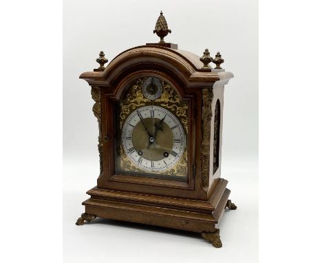 A walnut cased bracket clock with silvered dial, gilt detailing and acorn finial with German movement