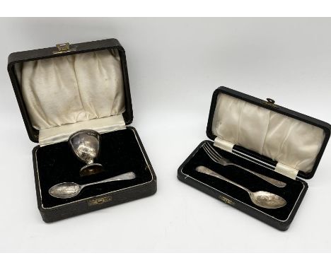 A cased hallmarked silver Christening set consisting of egg cup and spoon along with one other silver set of spoon and fork