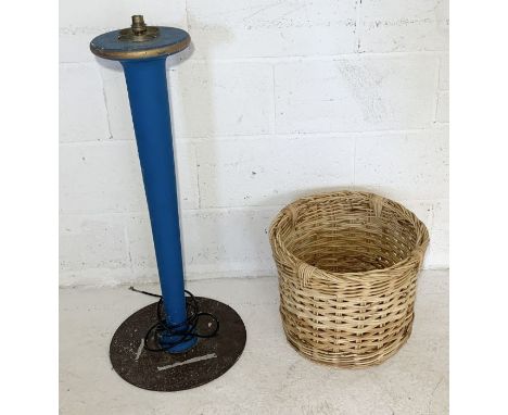 A handmade wooden standing lamp along with a wicker basket 