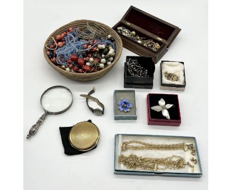 A collection of costume jewellery along with a silver handled magnifying glass etc.