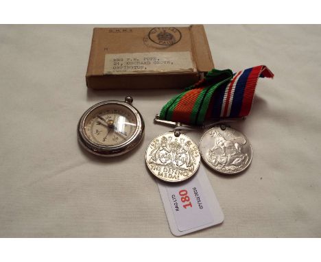 A 1939-45 Defence and War medal with box to MRS. F.M. POPE and a compass