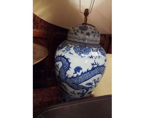 A large 20thC blue and white lidded ginger jar lamp having three toed dragon chasing a pearl of wisdom decoration, and silk s