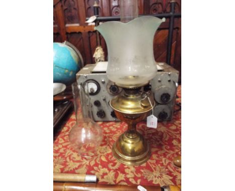 A brass and glass oil lamp with pale green etched shade