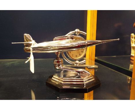 An Art Deco clock and chrome table lighter in the form of a jet