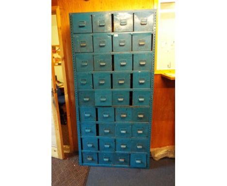A vintage industrial storage rack with thirty six metal drawers