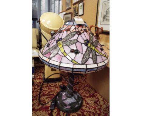 A Tiffany style lamp with dragonfly decoration to glass shade, resting on mosaic base