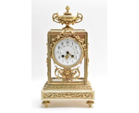 A late 19th century French mantle clock, having four bevelled glass panels applied with gilt metal mounts including vase fini