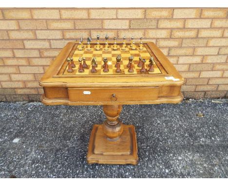 A chessboard table, approximately 66 cm x 57 cm x 57 cm and wood and metal chess pieces (7.5 cm king).