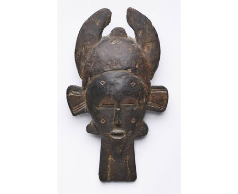 Maske Senufu "kpile", Elfenbeinküste.Holz, dunkel patiniert. Farbreste. Leicht aufgewölbte, spitzovale Form, bekrönt v. abgef