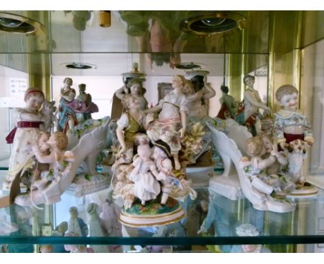 Assorted Continental porcelain figures to include a boy and girl with dog and cat, pair of figural candlesticks, pair of shoe