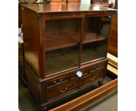 A mid-19th century mahogany glazed cabinet, with two double doors enclosing an adjustable shelf, the base with five frieze dr