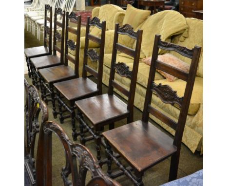 A set of six oak ladder back dining chairs, with solid seats and foliate carved back and top rail 