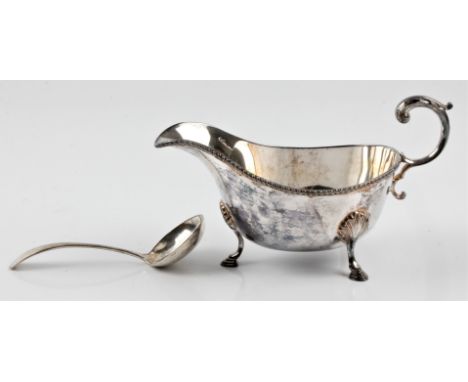 A hallmarked silver sauce boat, raised on four hoof feet, together with a hallmarked silver small ladle. BOOK A VIEWING TIME 