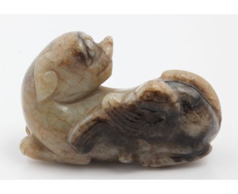 A Chinese green and brown Jade Foo Dog with a duck and with a wooden stand, approx 6cm x 3cm. BOOK A VIEWING TIME SLOT ON OUR