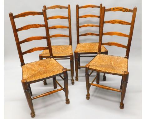 A set of four 19thC ash and elm ladder back chairs, each with a rush seat, on turned tapering legs, with pad feet. 