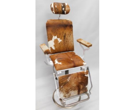 A vintage metal barber's chair, later upholstered in brown cow hide