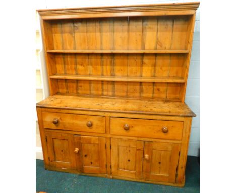 A Victorian and later pine dresser, the back with two plate shelves, the base with an arrangement of two deep drawers above t