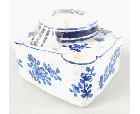 An 18thC faience blue and white pottery inkwell, decorated with flowers, the compressed square body with domed lid, numbered 