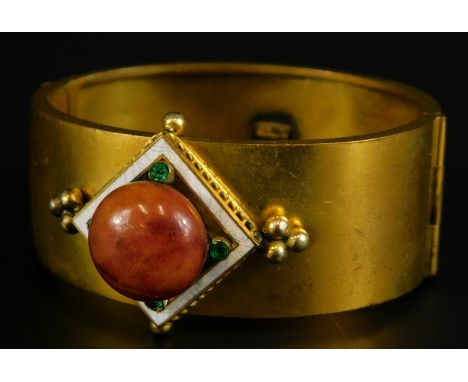 A Victorian bangle, set with a diamond shape, bearing a central orange stone, with four green paste stones, surrounded by whi