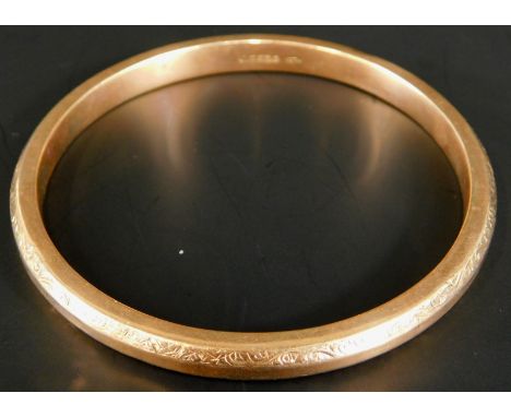 A 9ct gold bangle, with engraved floral decoration, hollow, 13.9g all in. 
