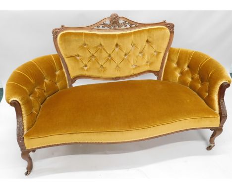 An Edwardian mahogany show-frame sofa, with button gold fabric, on cabriole legs, with ceramic castors