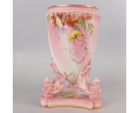 A Royal Worcester porcelain lamp base, decorated with flowers on a pink ground, with a triform plinth, 30cm high.