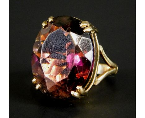 A 9ct gold dress ring, set with a large oval paste red stone, 9.3g all in. 