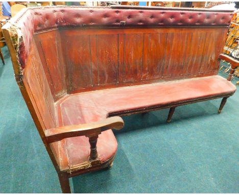 A Victorian mahogany railway waiting room corner bench, with a Rexine padded back and seat, panelled sections and shaped arms