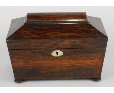 An early Victorian rosewood sarcophagus shaped tea caddy, the hinged lid enclosing two lidded divisions, on bun feet, 23cm wi