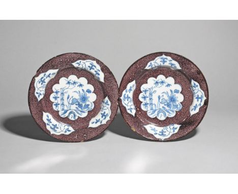 A pair of delftware plates  c.1750, probably Lambeth, the wells painted with a scallop-edged panel of bamboo and flowering br