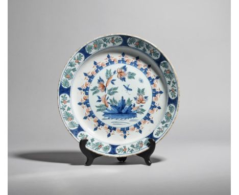 A Bristol delftware charger  c.1730, painted in blue, red and green with insects in flight above flowering Oriental plants, w